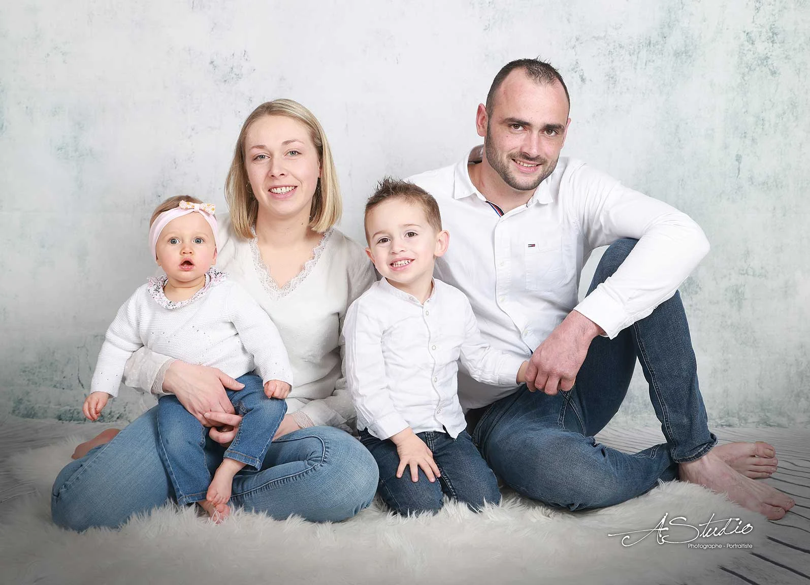 Portrait de famille avec parents et deux enfants photographié chez AStudio à Fougères